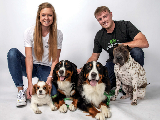 Owners of paws and pints, Kyle and Megan, pose with their four dogs